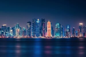 Captivating night view of Doha's illuminated skyline reflecting over the water.