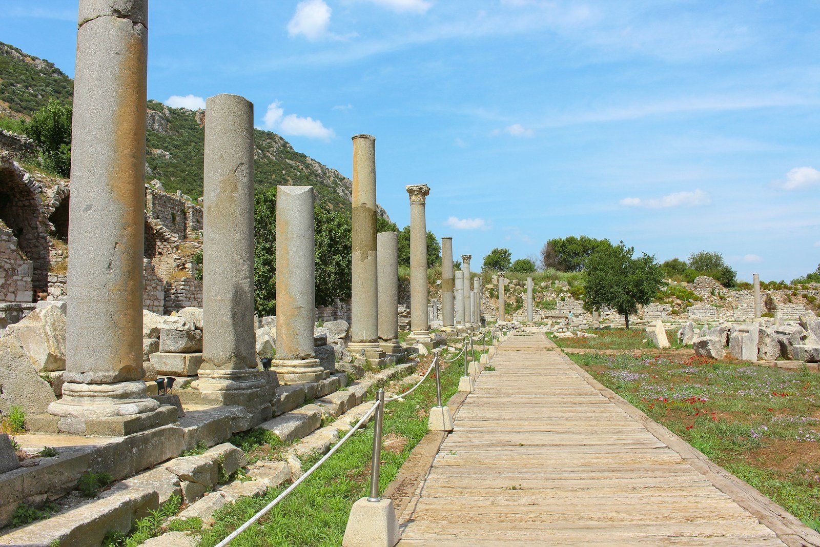 a long walkway between two large stone pillars