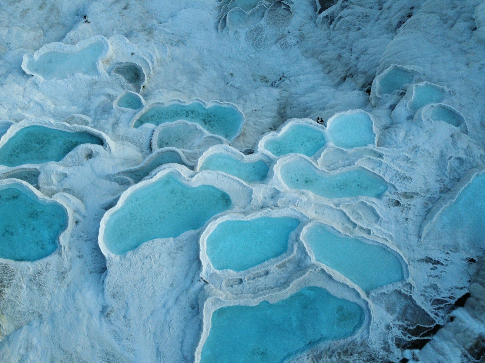 A group of blue and white rocks in the water
