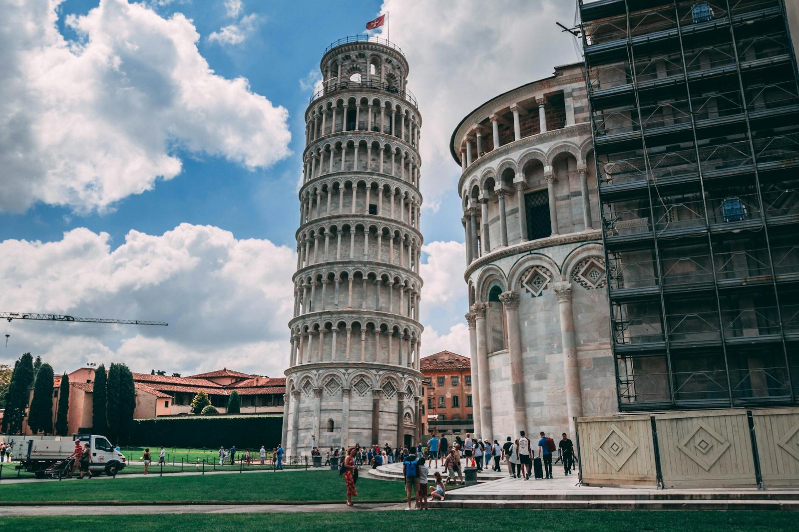 Capture of the iconic Leaning Tower of Pisa and tourists enjoying a sunny day.