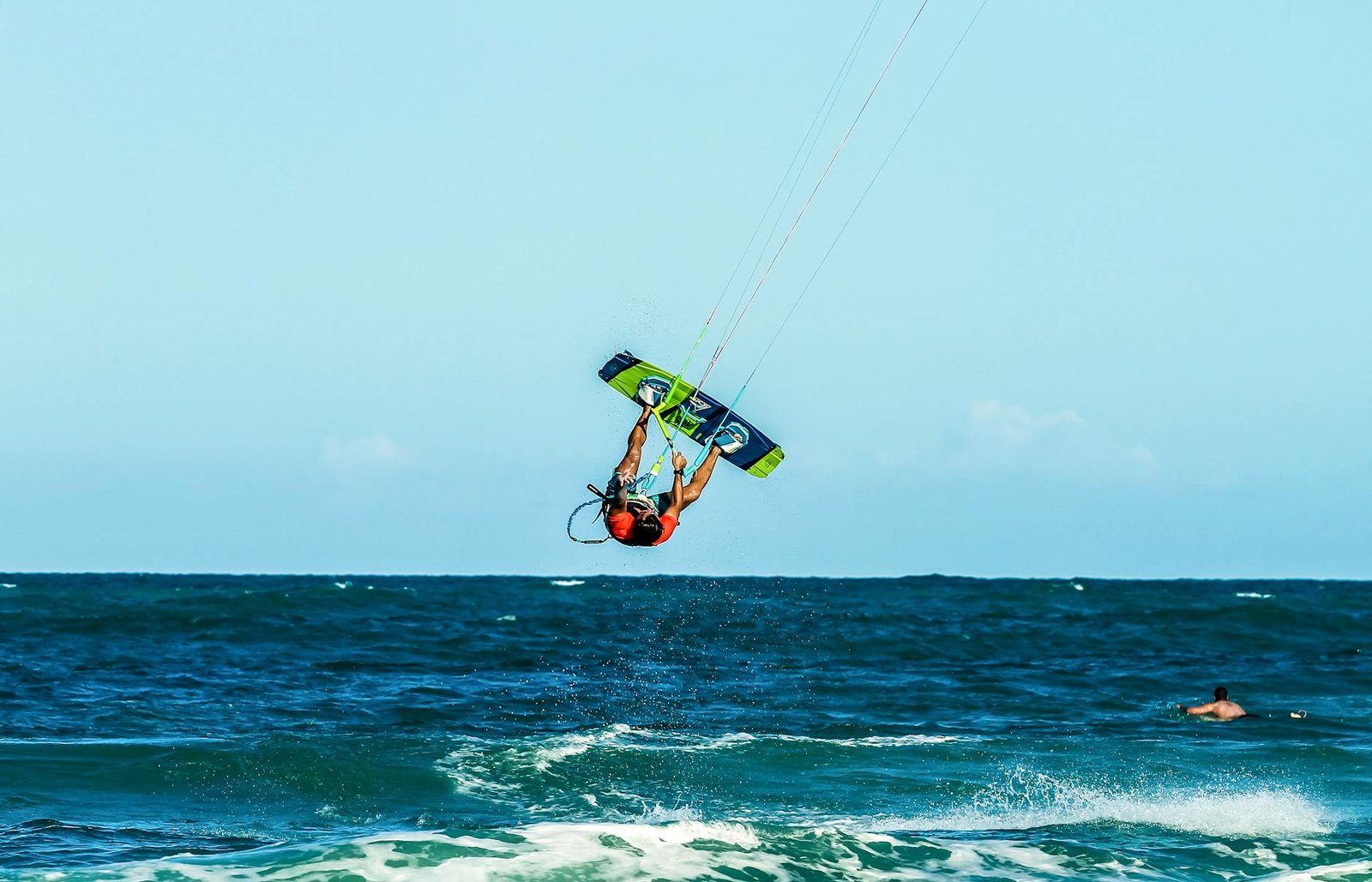 Dynamic kitesurfing action captured on the beautiful coast of Brazil under bright summer skies.