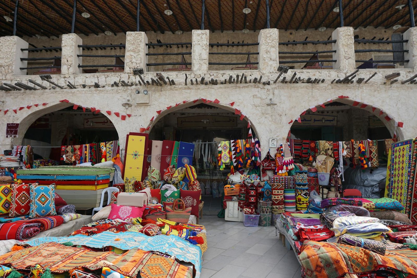 Vibrant display of textiles and crafts in Souq Waqif, Doha, showcasing Middle Eastern culture.